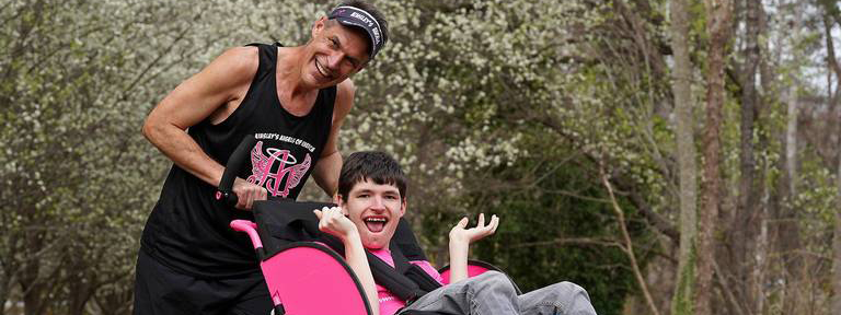 Dr. Johncock pushing his son Logan in a running stroller during a marathon